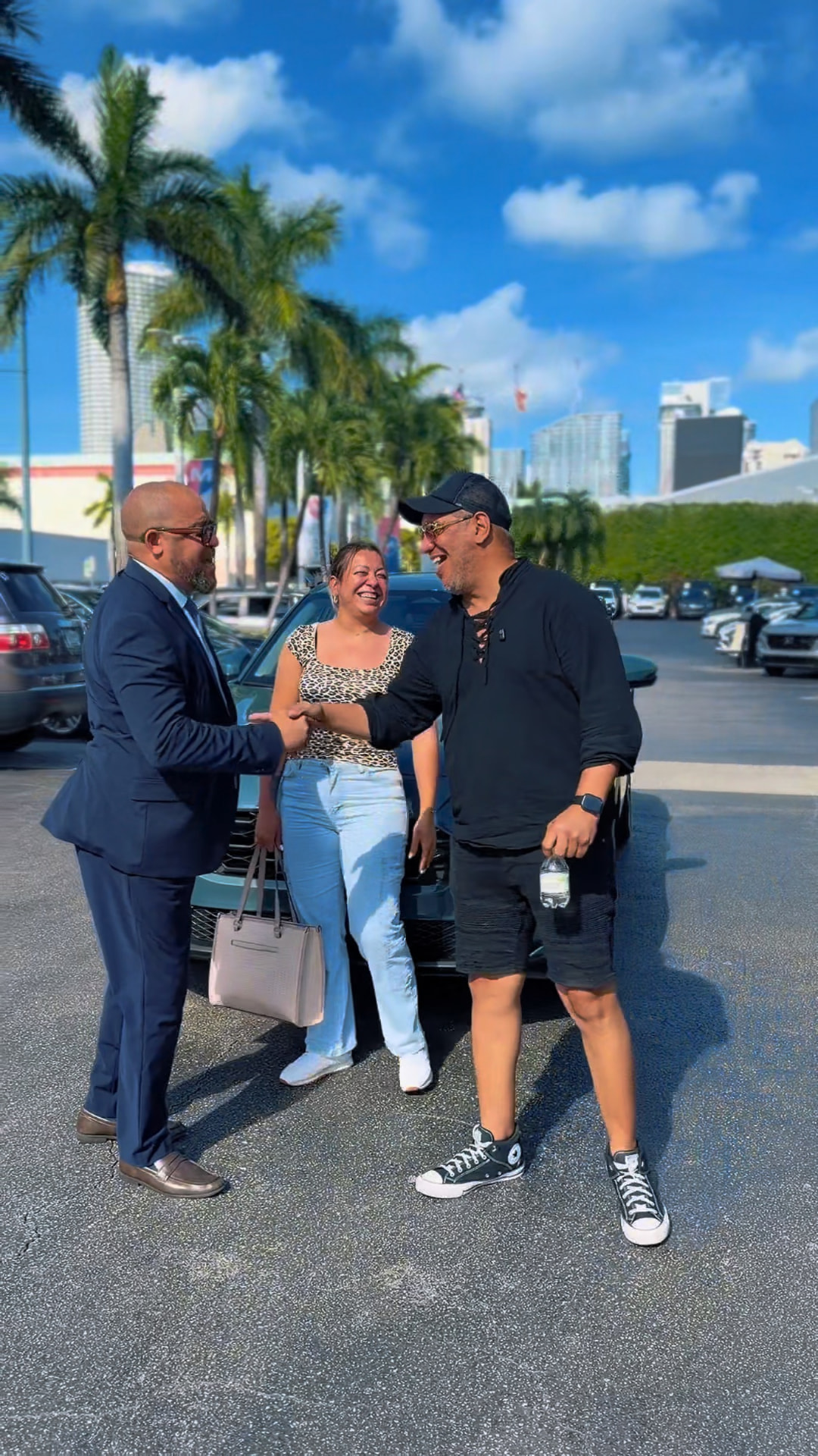 Alexander Montalvo conversando con clientes junto a su vehículo en Miami