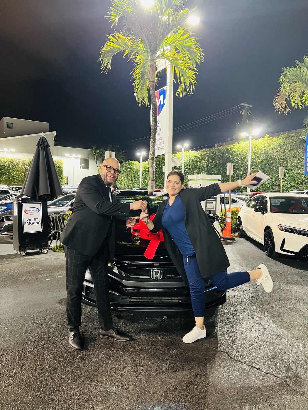 Alexander Montalvo entregando las llaves a una clienta feliz junto a su SUV nueva en Miami
