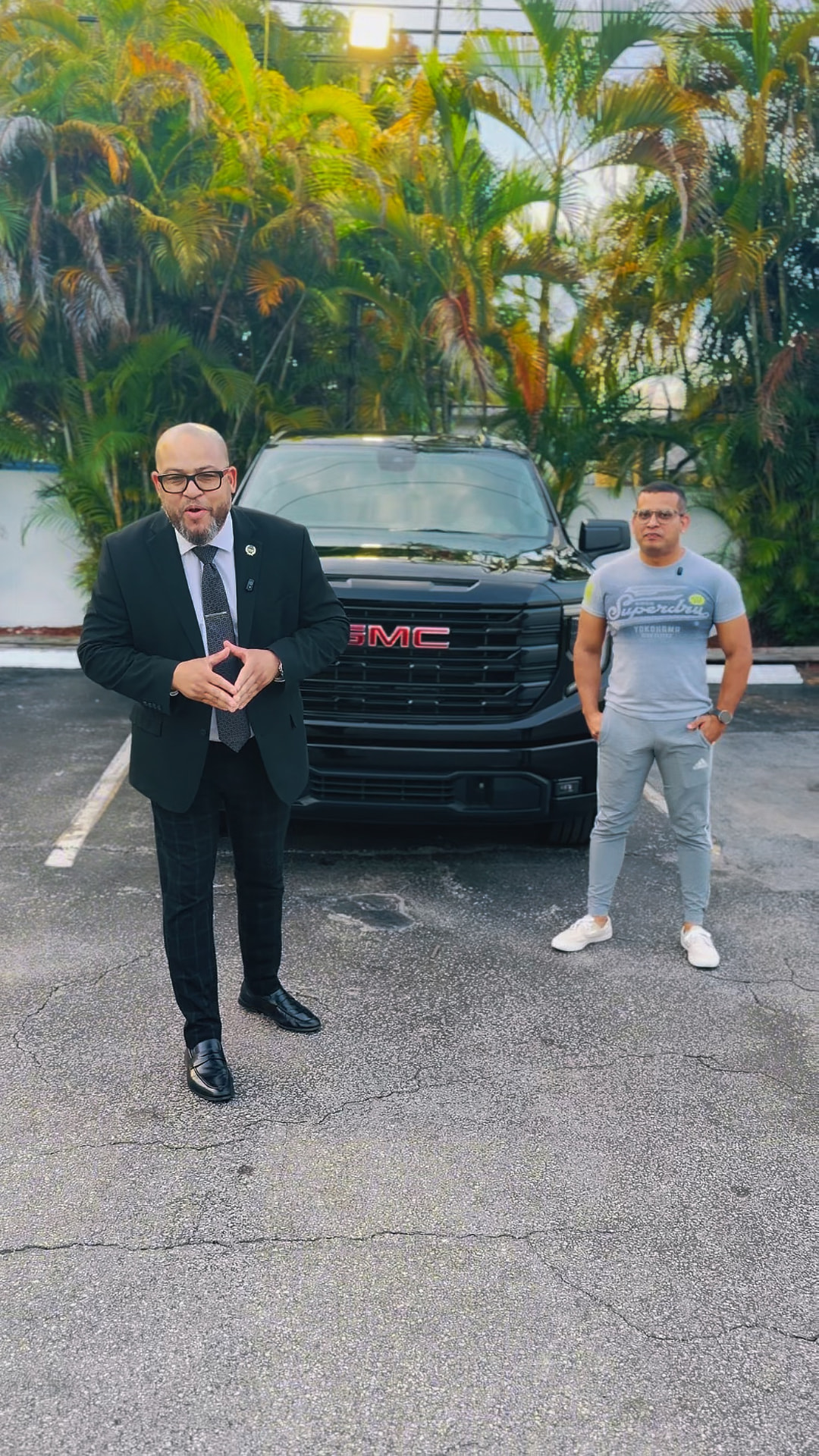 Alexander Montalvo con un cliente junto a una camioneta GMC